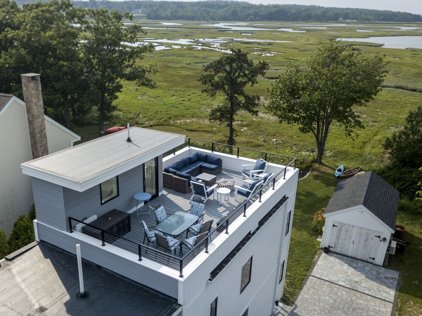 Aerial view of a rooftop deck overlooking a coastal marsh.