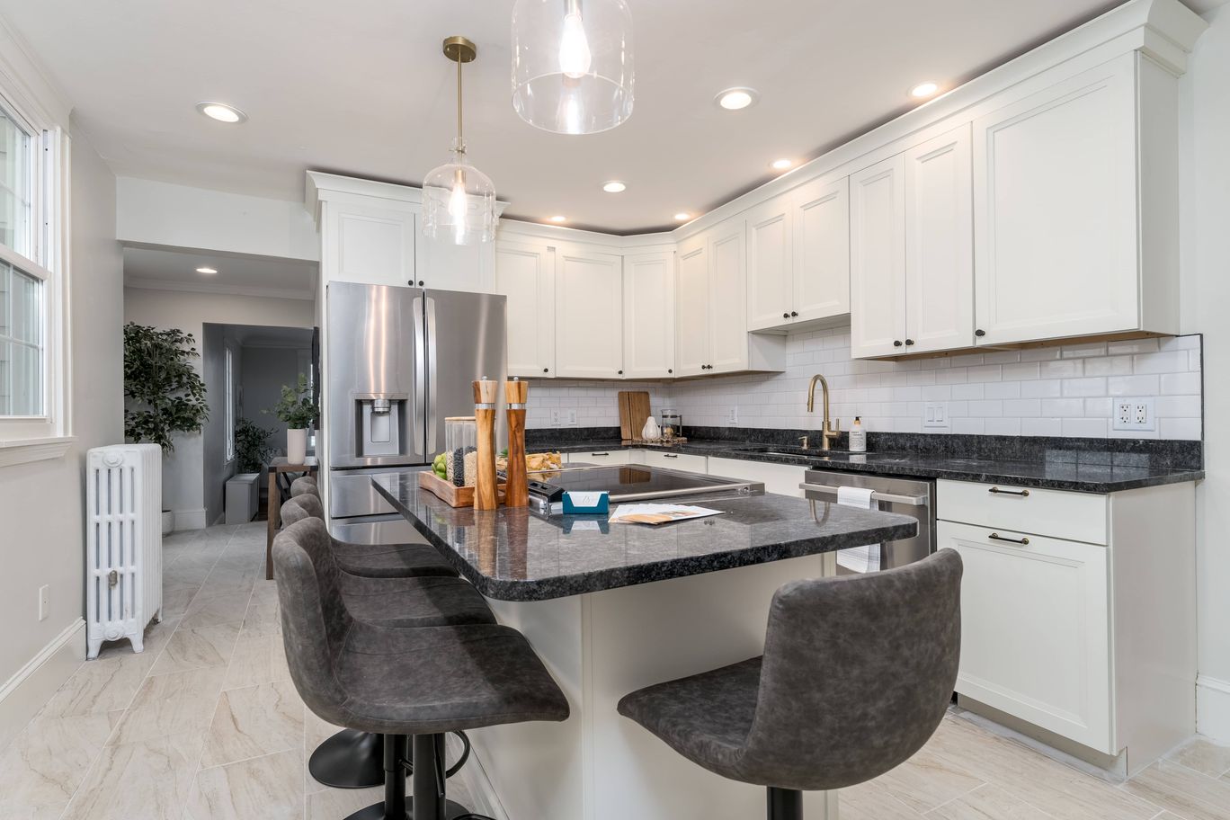 Kitchen with a dark granite island and pendant lighting.