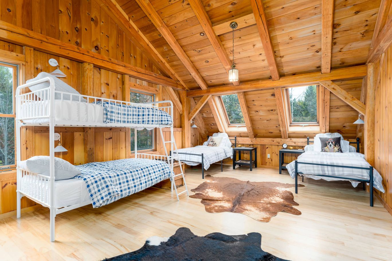Bunk room in a timber frame house with exposed rafters.