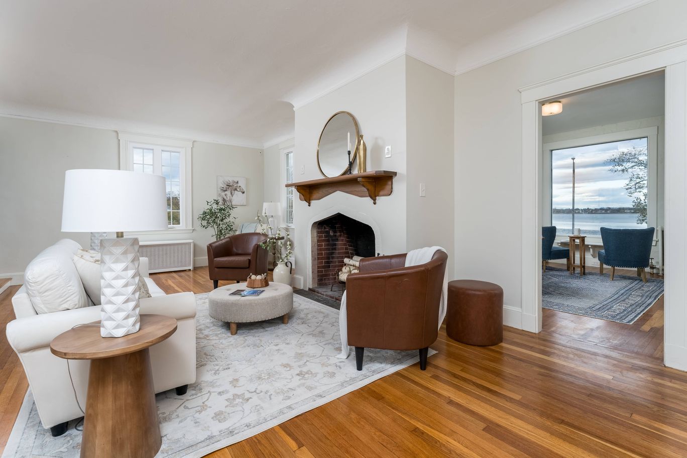 Living room with an arched brick fireplace and hardwood floors.