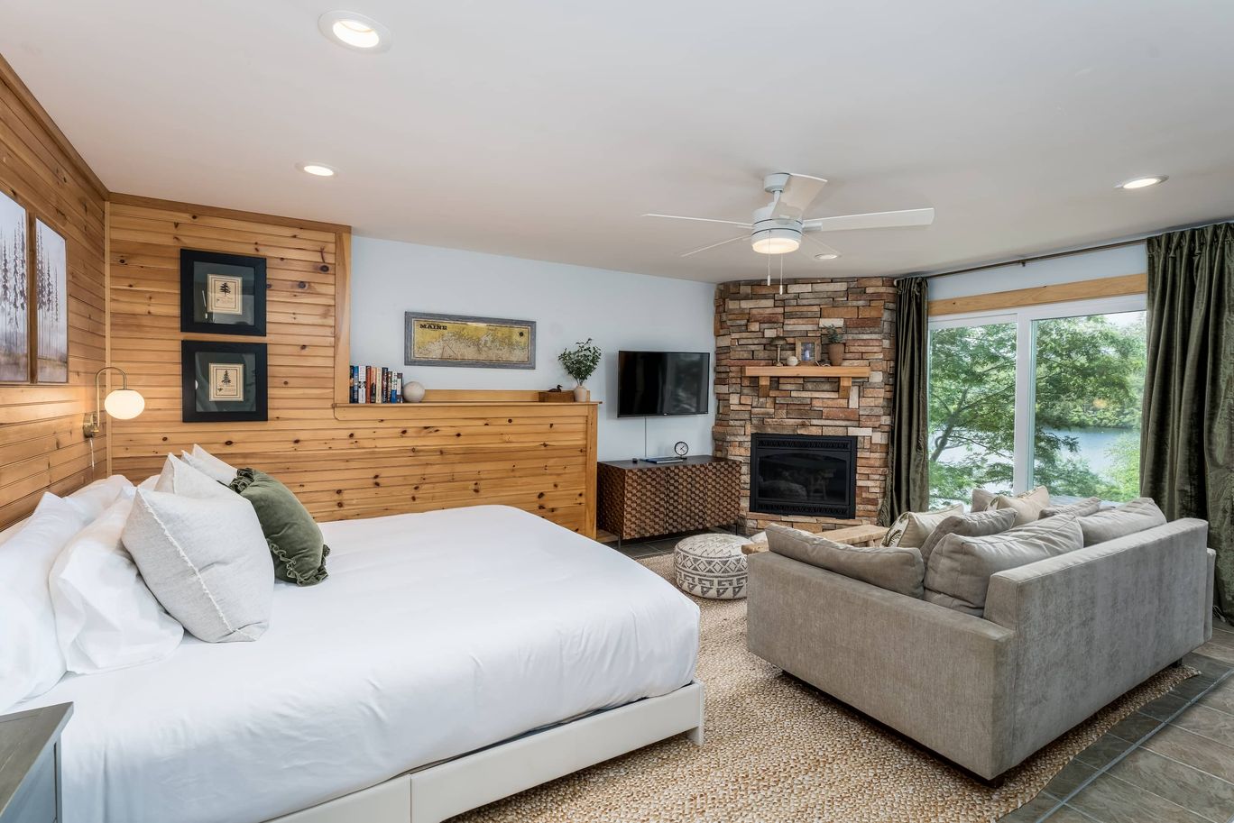 Bedroom with a wood accent wall and a view onto the lake.